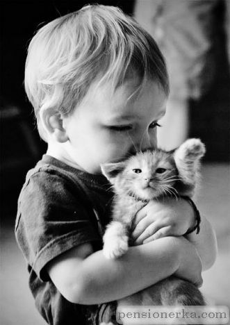 Мальчик обнимает котенка