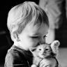 Мальчик обнимает котенка